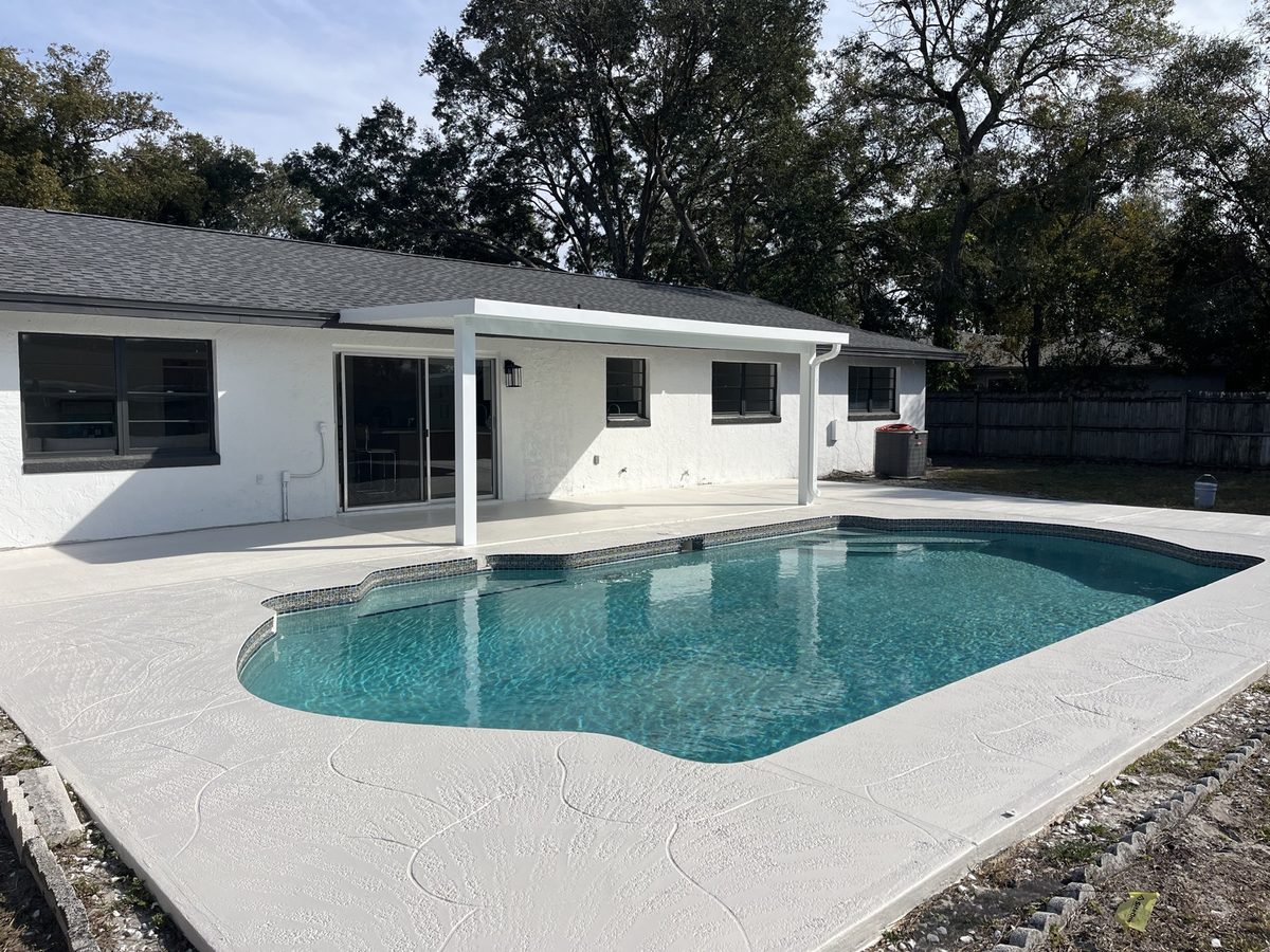Screened backyard pool with a freshly finished paver deck
