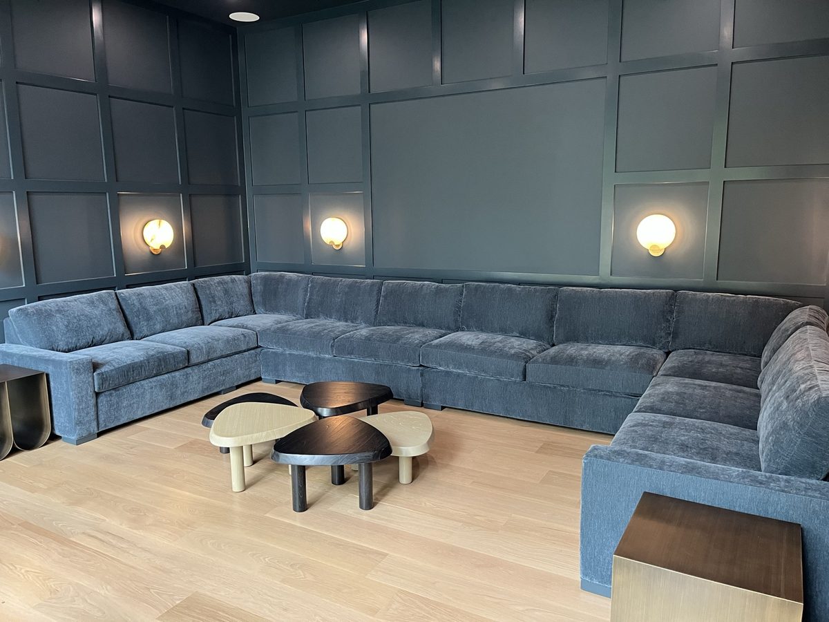 Media room with grid-paneled walls and a wraparound sectional
