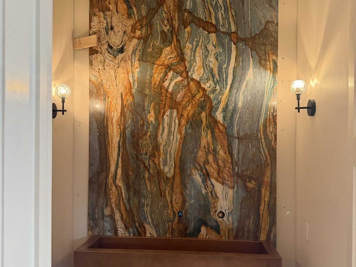 Entry niche wrapped in a backlit book-matched stone slab
