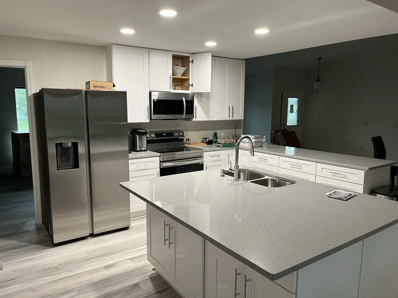 Renovated kitchen with white cabinetry and a quartz island